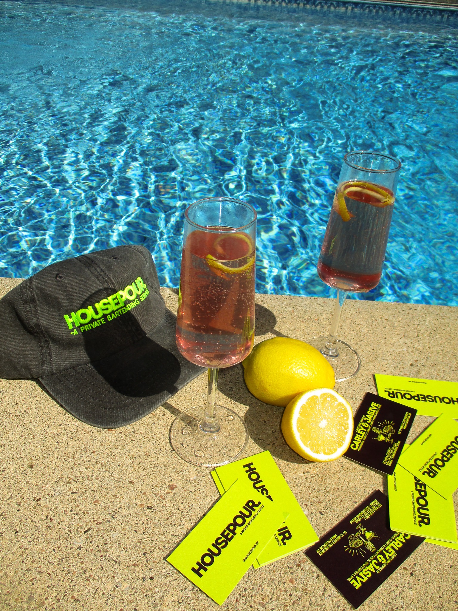 House Pour drinks, hat and cards beside the pool